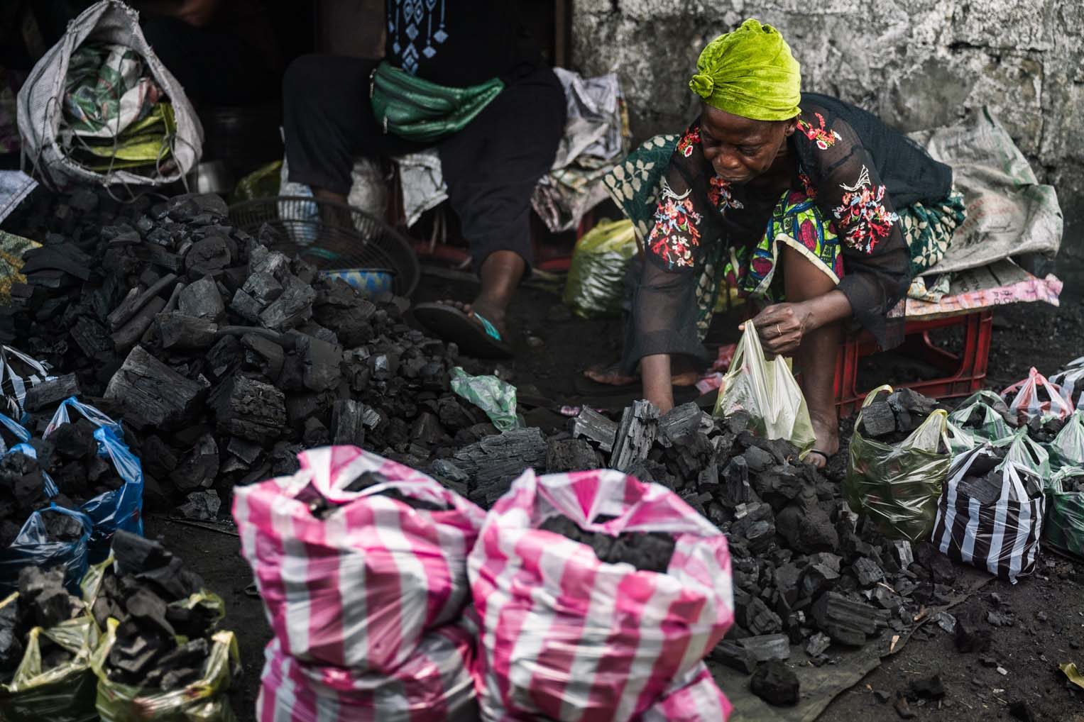 Charcoal vendors work by hand to package fuel for cooking. It’s dusty, exhausting work—but a vital income source for many women in the community.