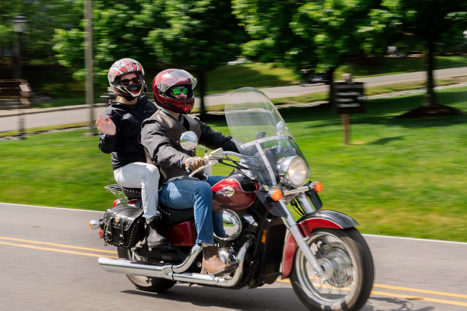 A biker duo waves as they make their way with hundreds of bikers toward the two-hour route.