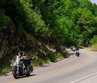 Riders wave as they curve through the Blue Ridge Mountains during the High Country Warrior Ride.