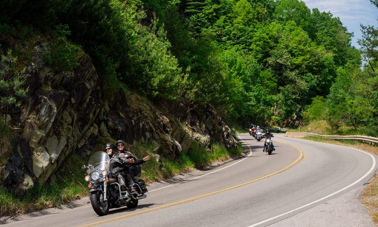 Riders wave as they curve through the Blue Ridge Mountains during the High Country Warrior Ride.