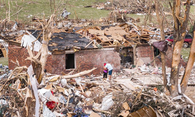 People hug amid the devastation brought by an EF3 tornado in London, Kentucky.