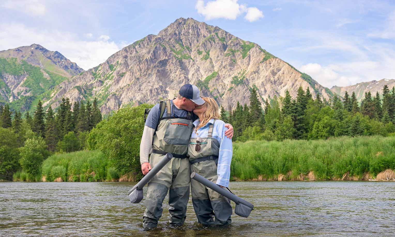 a couple embraces and kisses as they pause in their wading at Kijik River, Lake Clark National Park during Operation Heal Our Patriots 2025