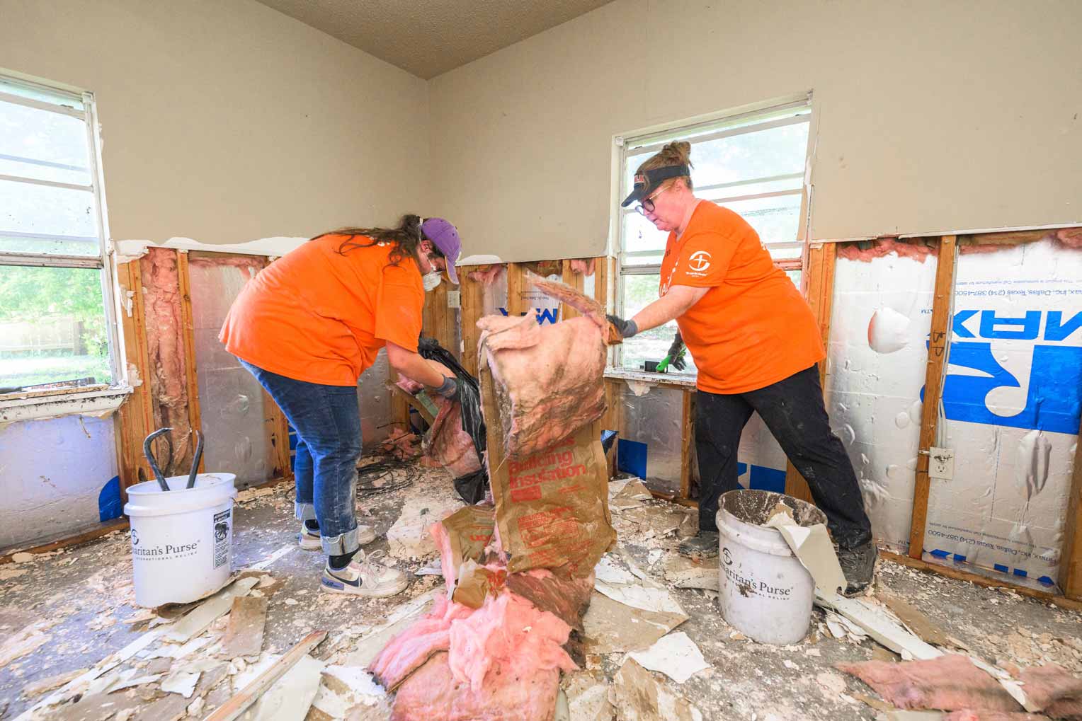 Drywall is removed, along with insulation, to prevent mold growth in the flooded rooms.