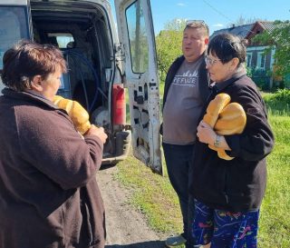 Pastor Yehven and two recipients of bread and water