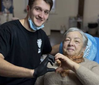 Dentist and patient make heart sign with hands