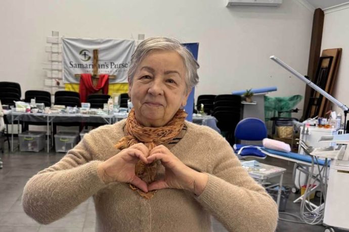 Ukrainian dental patient makes heart sign with hands