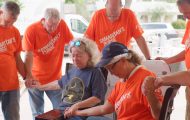Samaritan's Purse volunteers, with Helping in Jesus' Name orange shirts, gave a Bible to a local resident and prayed with her in San Angelo, Texas, where flash flooding hit the community in Tom Green County on July Fourth.