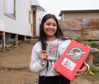 Girl in Chile with shoebox gift and the notebook it contained