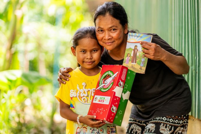 Cambodian mother and daughter with shoebox gift and Gospel booklet from Samaritan's Purse