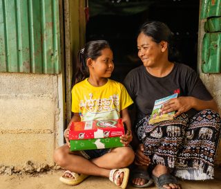 mother and daughter with shoebox gift and Gospel booklet