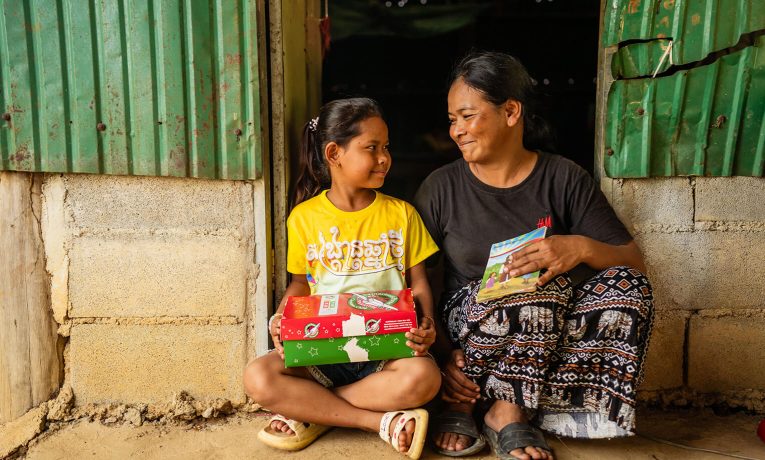 mother and daughter with shoebox gift and Gospel booklet
