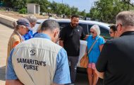Samaritan's Purse group praying over new vehicle for Texas flood survivor.