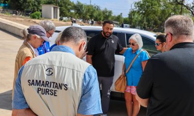 Samaritan's Purse group praying over new vehicle for Texas flood survivor.