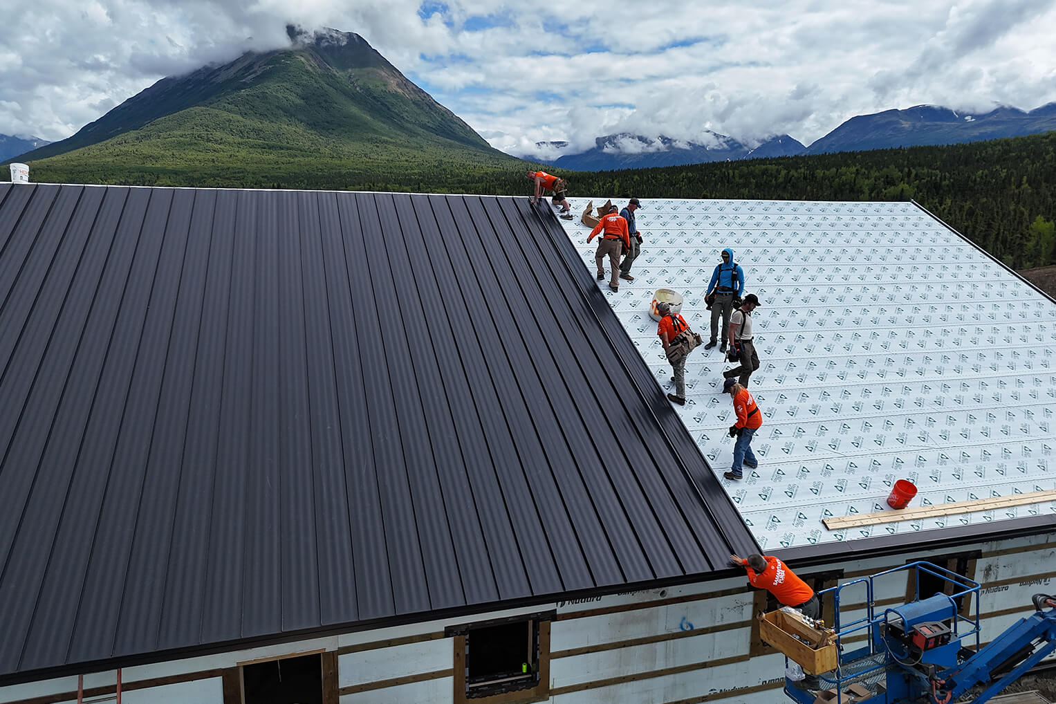 Volunteers moved from framing to metal roof in recent days.