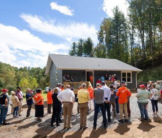 Voluntarios, amigos y familiares reunidos para la dedicación de la nueva casa de Sherwood.