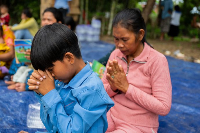 Mother and son pray together at an Operation Christmas Child outreach event