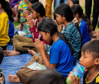 Cambodian children praying at an Operation Christmas Child outreach event