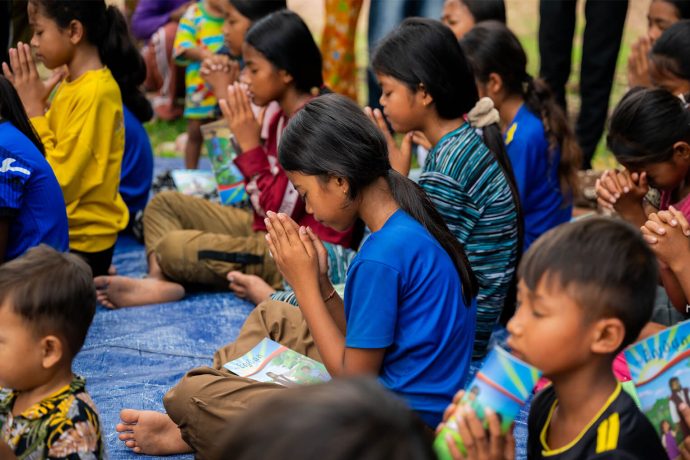 Cambodian children praying at an Operation Christmas Child outreach event