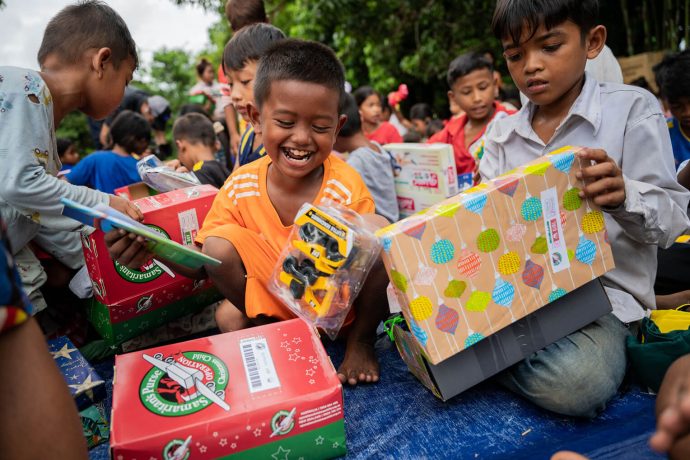 Boy smiles at truck toy in his shoebox gift
