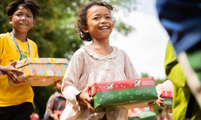 Excited boy and girl hold shoebox gifts