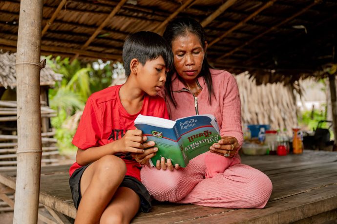 Cambodian mother and son study Bible