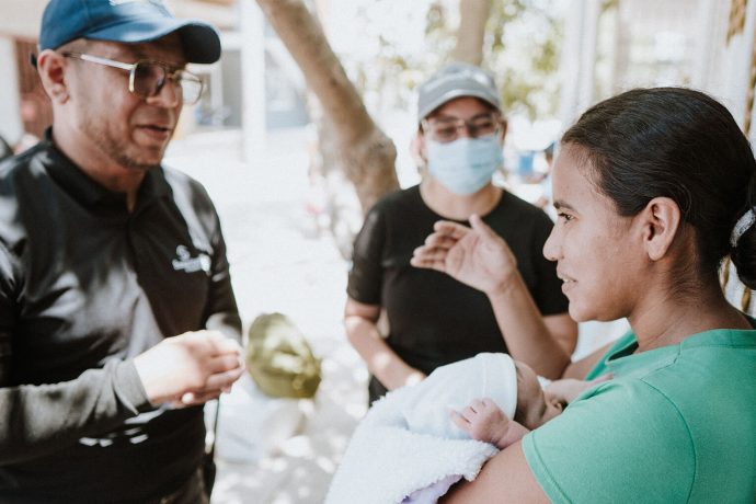 Christian Nuñez (left), a trained Samaritan's Purse chaplain, shares God's love with a patient at the clinic. Preaching the Gospel remains our goal as we serve Colombian mothers in Jesus' Name. 