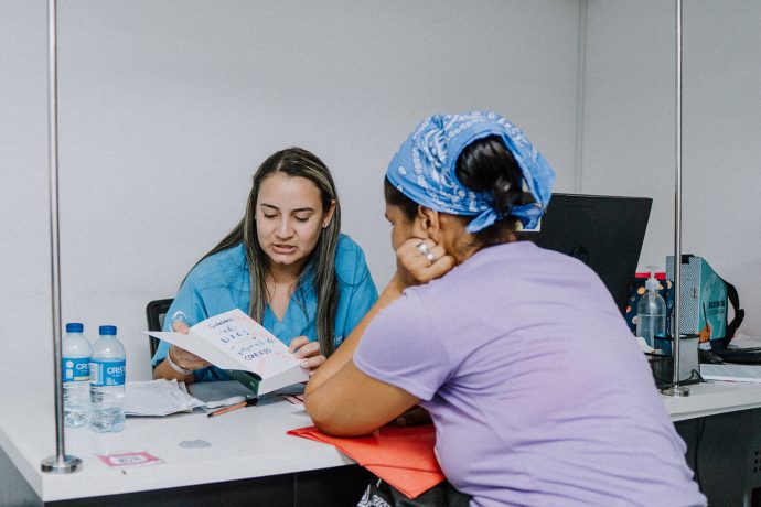 A Samaritan's Purse clinic staffer shows a patient her new Bible after her health checkup. 