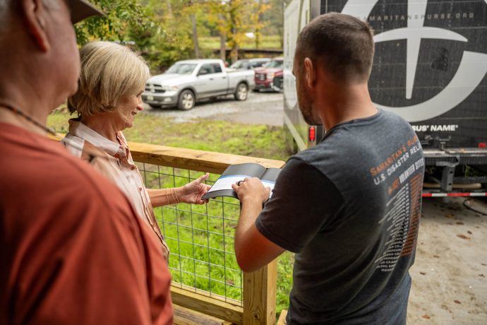 Samaritan's Purse staff member opens new Bible for the homeowners