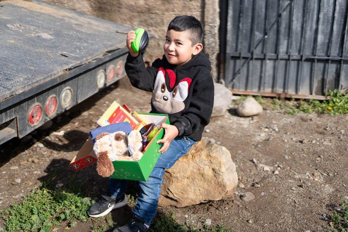 Augustin grips football he found in his shoebox gift