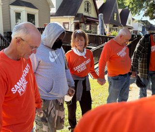 Los voluntarios oran con un propietario afectado por las inundaciones en Milwaukee, Wisconsin.