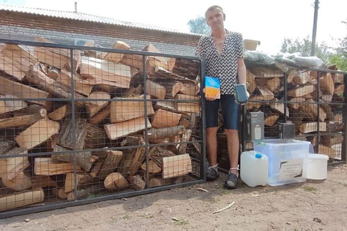 Ukrainian man with firewood and Bible he received from Samaritan's Purse
