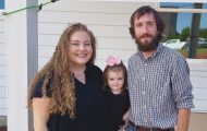 The Egger family poses for a photo in front of their new home built by Samaritan's Purse.