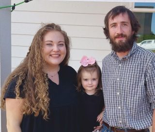 The Egger family poses for a photo in front of their new home built by Samaritan's Purse.