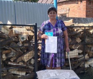 Ukrainian woman with firewood and Bible from Samaritan's Purse