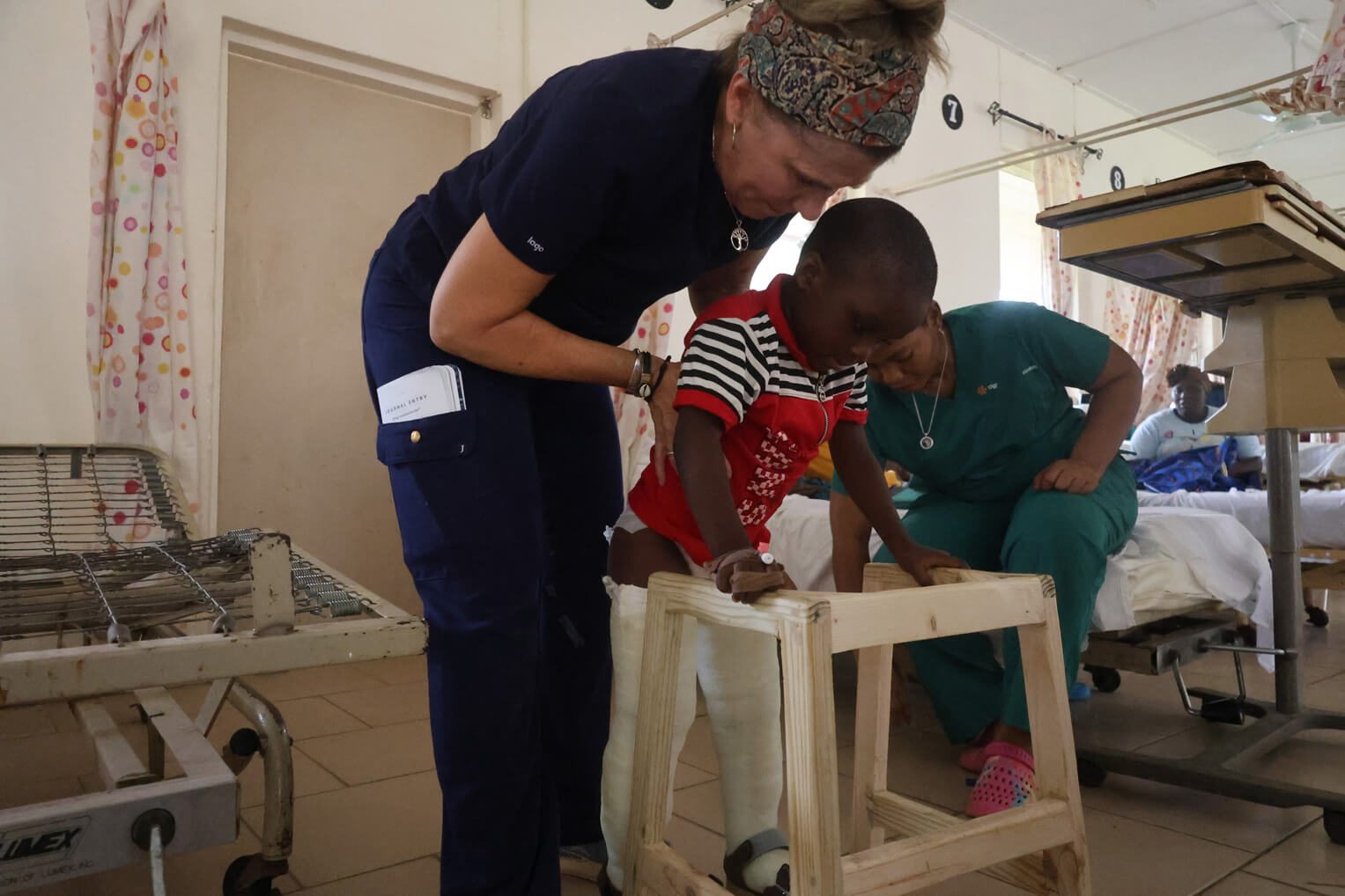 Tracy-Lynn Schuster, a physical therapist on the orthopedic team, helps Abraham walk after his successful surgery.