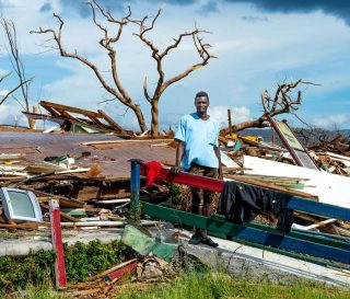 A man stands among the splintered remains of his home in Black River, Jamaica, after Hurricane Melissa destroyed the area.