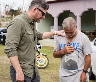 Samaritan's Purse COO prays with a resident of southwest Jamaica.