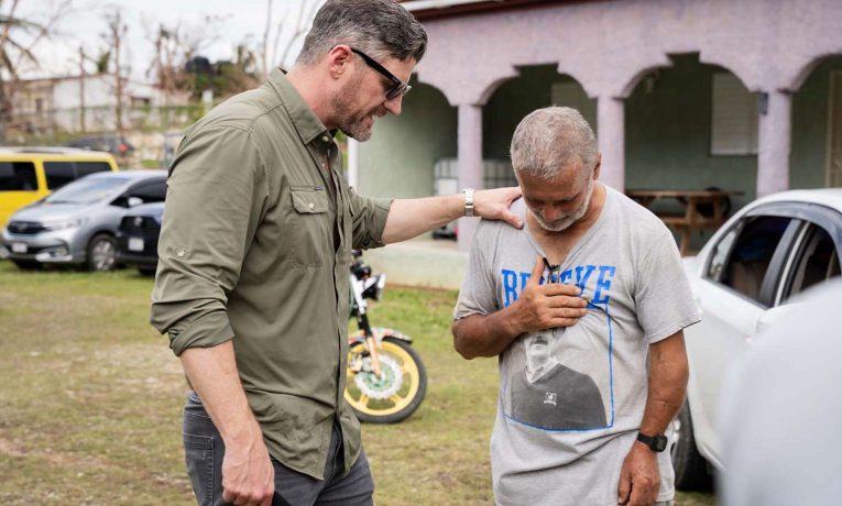 Samaritan's Purse COO prays with a resident of southwest Jamaica.