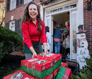 Marika at her front door with shoeboxes
