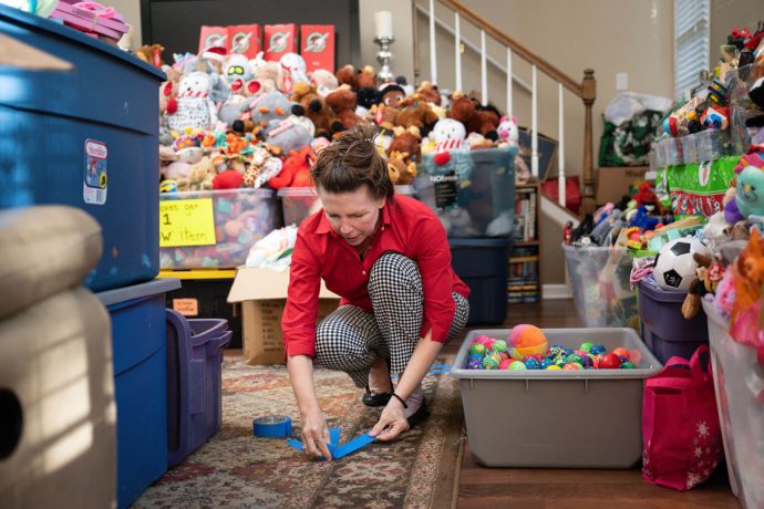 Marika tapes arrows on the shoebox packing party location floor