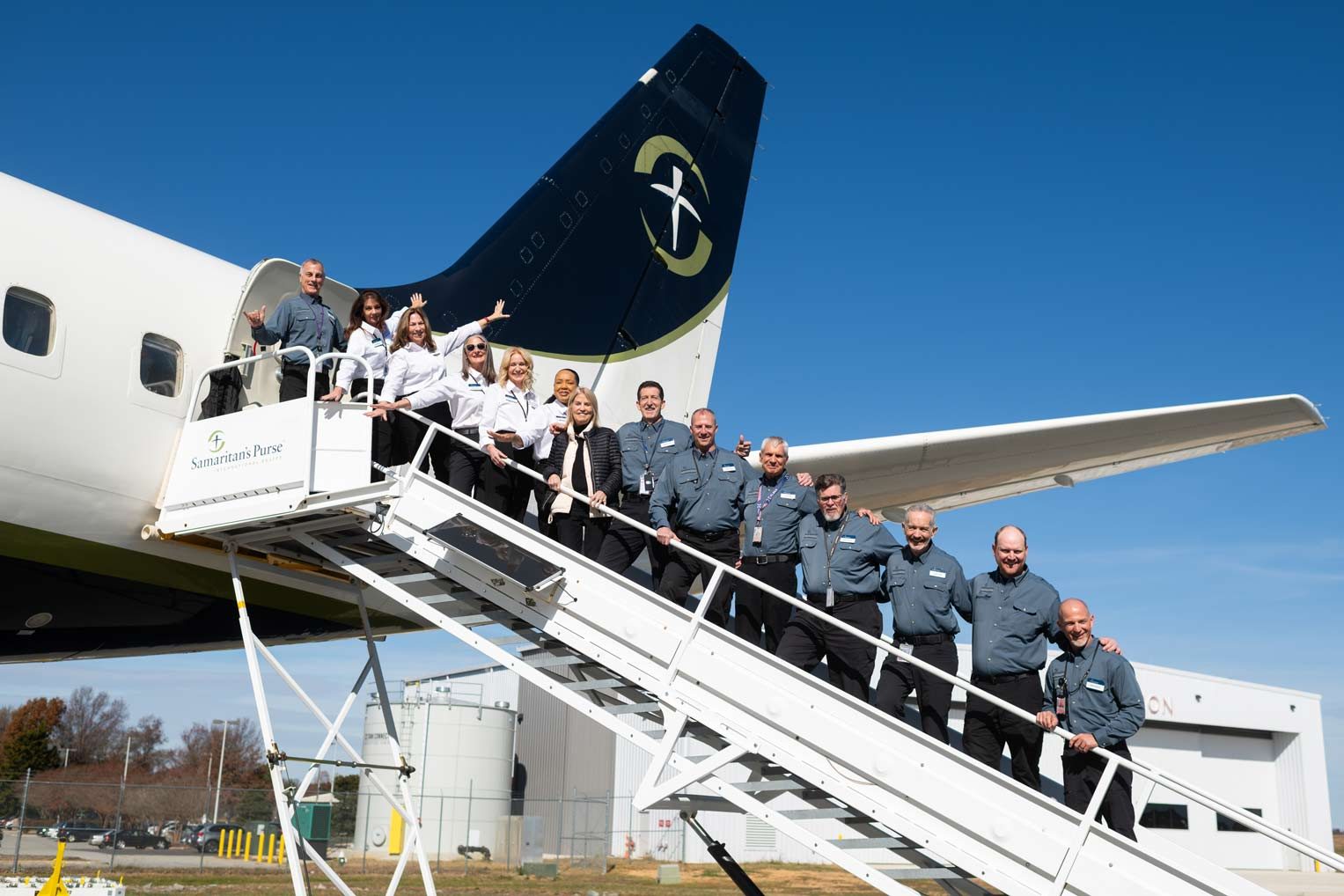 2592US-A-1121 Samaritan’s Purse Mission Aviation Services crew gather on the aircraft stairway to celebrate the ministry’s expanding fleet and the many years of service provided by the DC-8.