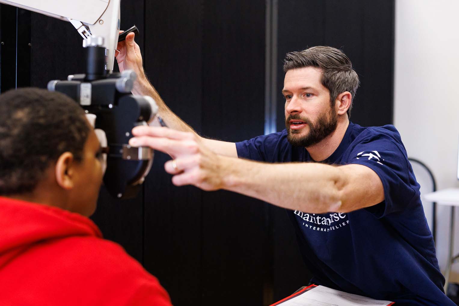 Optometrist Steven Miller performs an eye examination during the clinic.