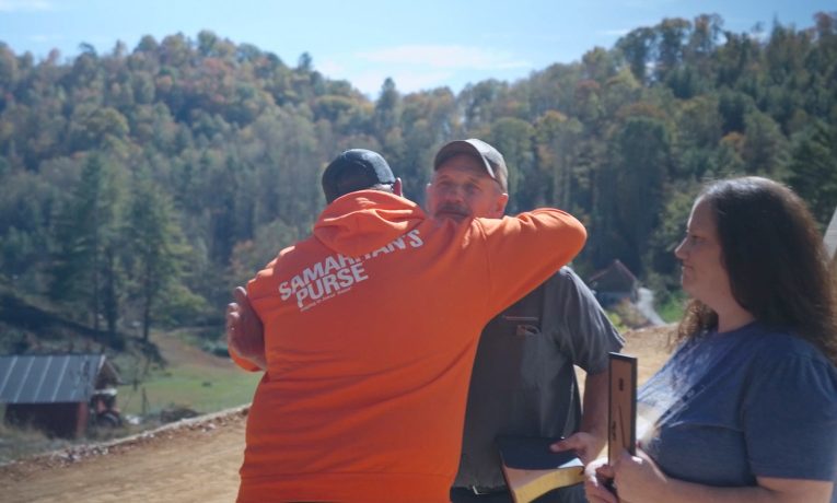 A Samaritan’s Purse rebuild team member welcomes the Murphys to their new home in Burnsville during a special time of prayer and encouragement. Their mobile home was destroyed during Hurricane Helene.