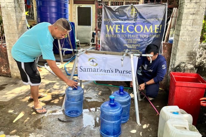 Community members in the Philippines fill jugs with clean, drinkable water out of the Samaritan's Purse water taps.