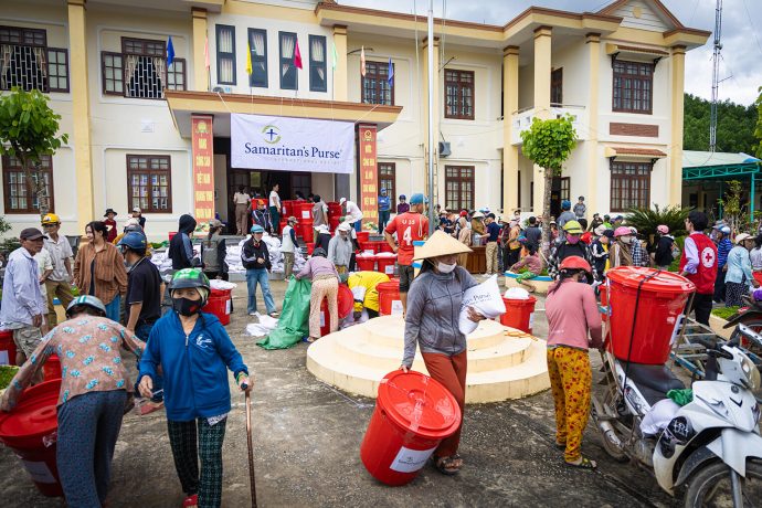 Residents in central Vietnam crowded a local town center to receive supplies provided by Samaritan's Purse. Each red bin holds food, hygiene products, and more relief supplies to help families get back on their feet. 