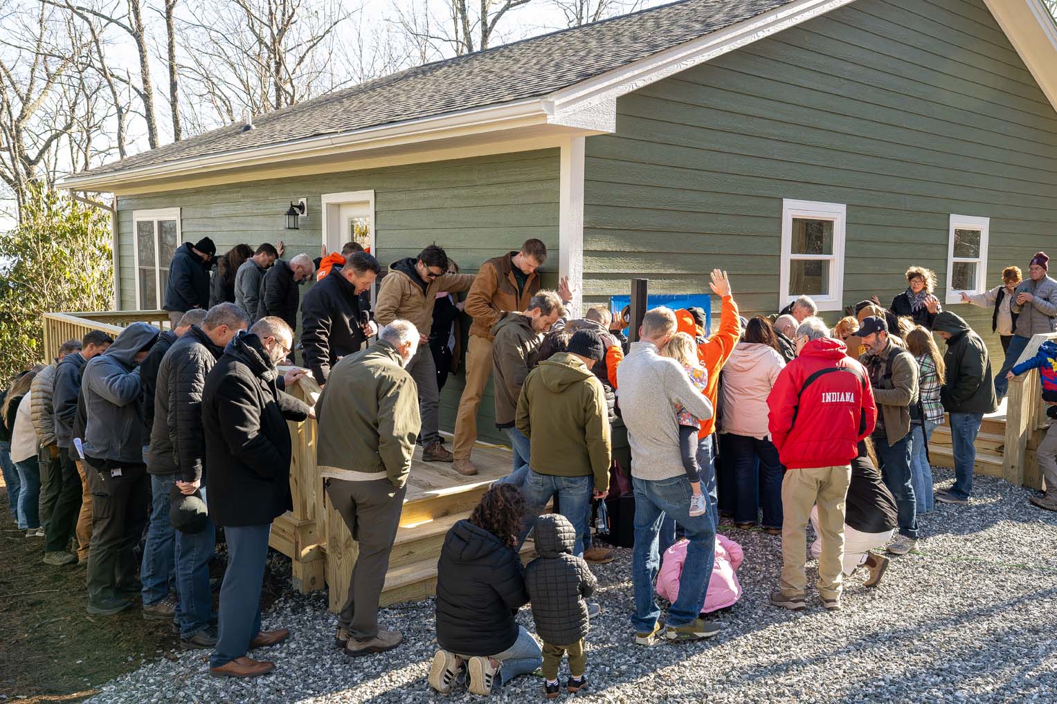 As their home is dedicated, it is lifted up in prayer by the the team and loved ones.