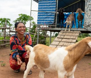 A woman in Cambodia smiling because of the gift of goats to help support her family.