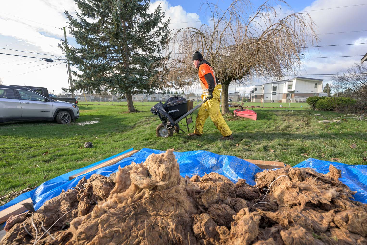Across muddy yards and water-soaked neighborhoods in Sumas, Washington, volunteers hauled ruined insulation and debris away from homes overwhelmed by rising rivers.