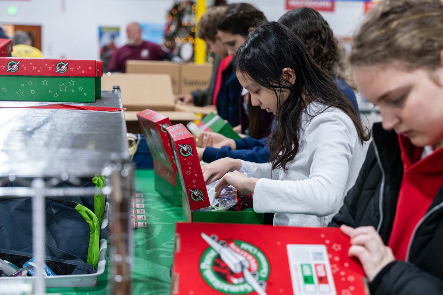2595US -B1-509 Volunteers of all ages join in the effort of preparing shoebox gifts for children in need.