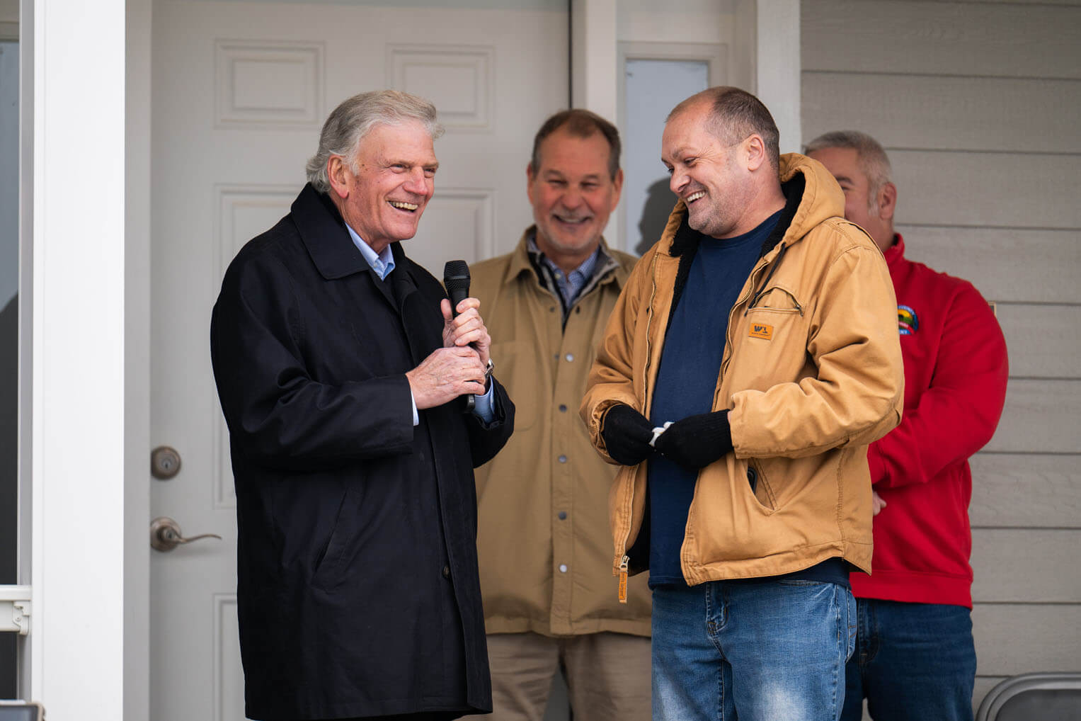 Graham laughs with Paul Johnson as they celebrate the completion of his new home.